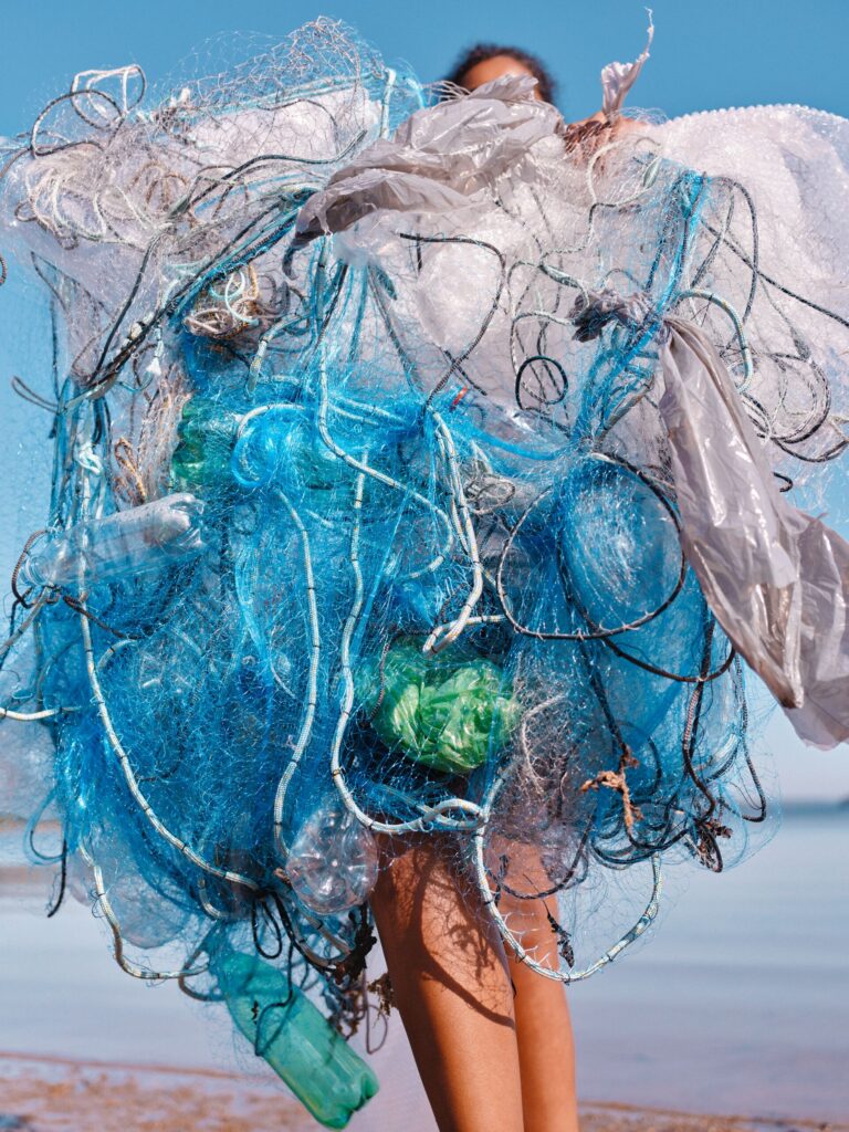 Image of person holding plastic caught in fishnet.