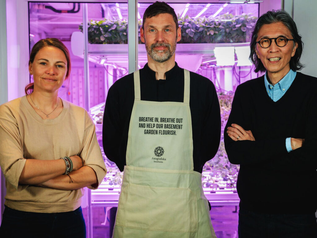 Christiane Dolva, Strategy Lead Planet Positive at H&M Foundation, Martin Wall, Executive Chef and “Planet Keeper” at Fotografiska and Edwin Keh, CEO at HKRITA standing in front of Fotografiska's hydroponic garden, where the CO2 is released at night.